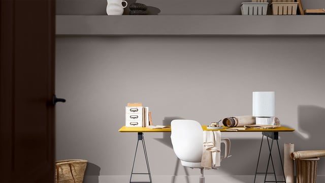 Helder thuis kantoor met witte stoel en houten bureau, met boeken en accessoires als decoratie.