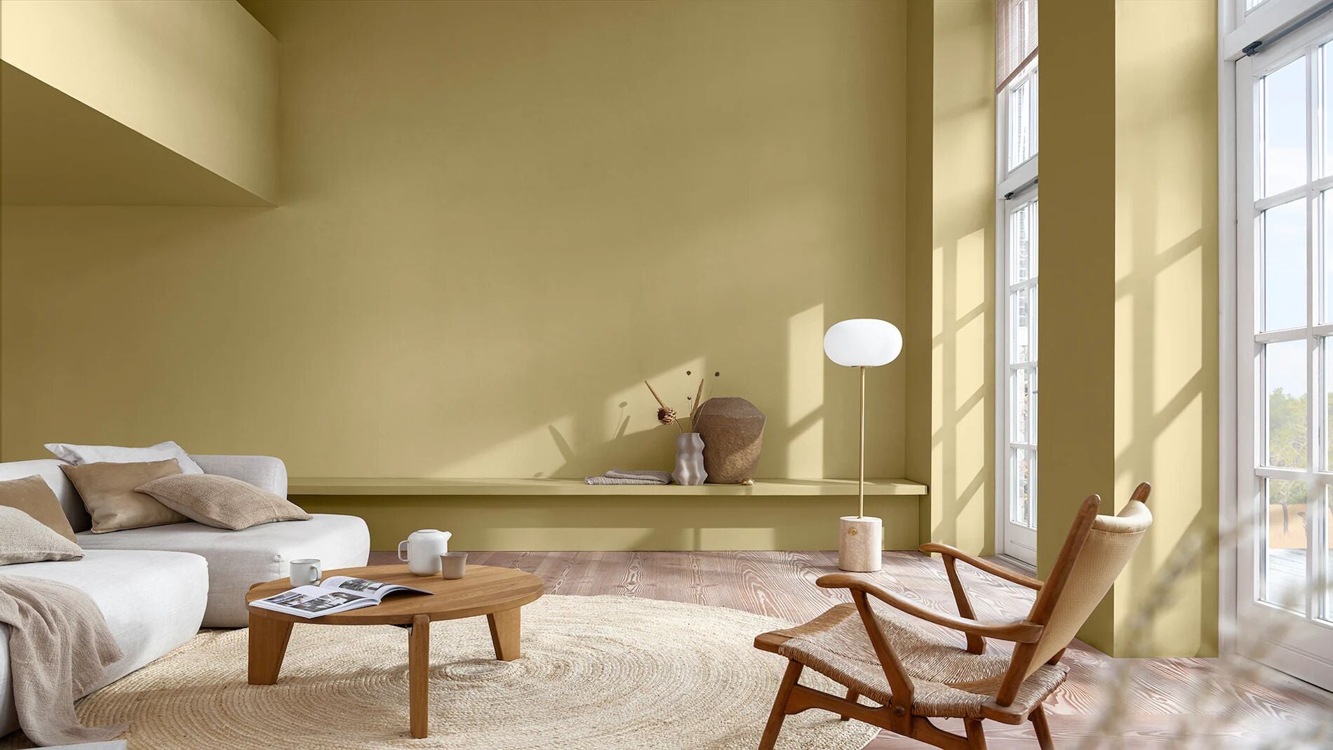 Minimalistische woonkamer met zachtgele muren, natuurlijk licht en houten meubels
