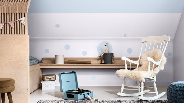 Lichte thuiskantoorsetting met houten bureau, open laptop en witte schommelstoel