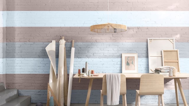 Helder thuiskantoorhoekje met houten bureau en stoelen tegen een geschilderde bakstenen muur