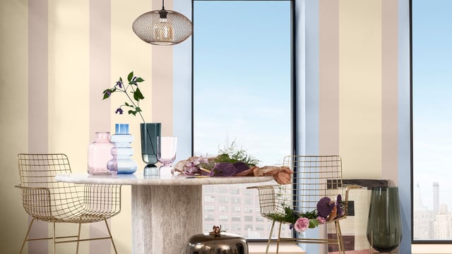 Moderne thuiskantoorruimte met bureau, draadstoelen, bloemen en daglicht door grote ramen