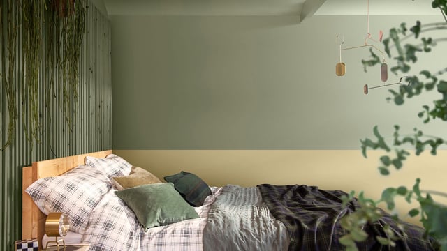 Slaapkamer in groene tinten met bed, geruit beddengoed en hanglampen boven het bed.