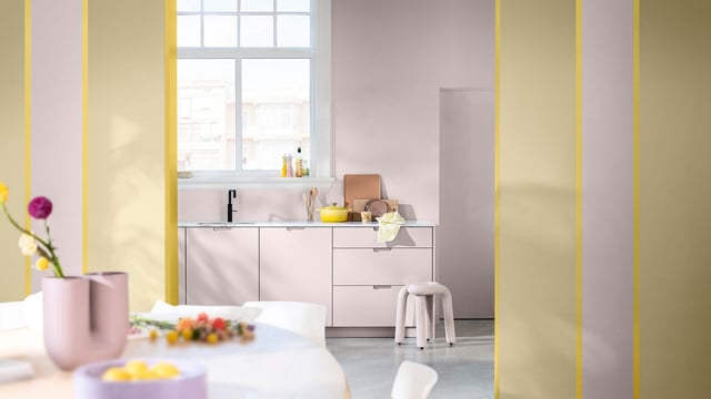 Lichte keuken met witte kasten, raam, barkrukken en gele decoratieve panelen