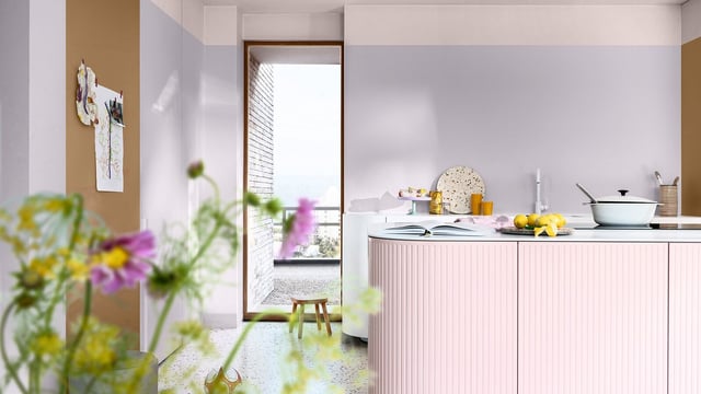 Lichte moderne keuken met roze kasten, witte muren en servies op het werkblad