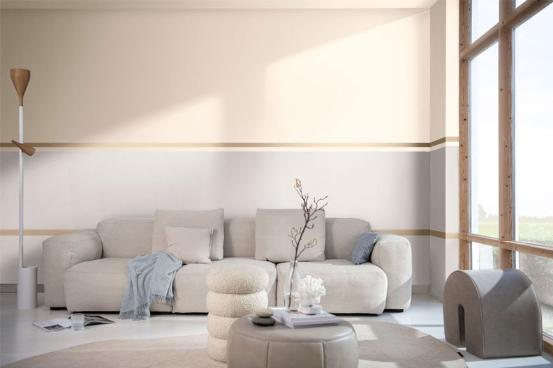 Lichte woonkamer met beige bank en zachte decoratie