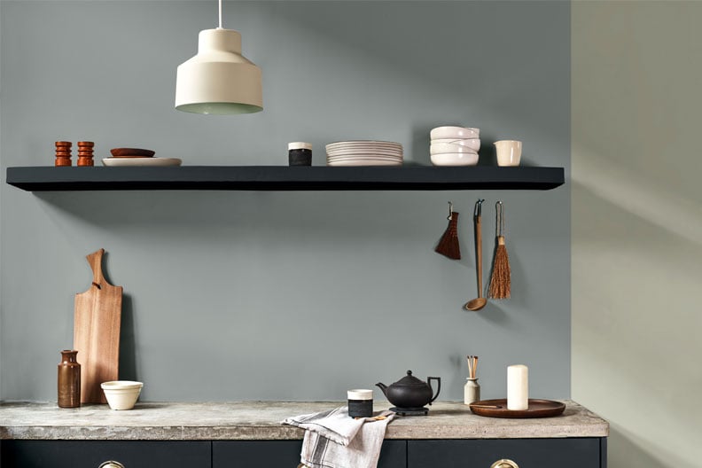 Stijlvolle keuken met grijze muur en zwarte plank