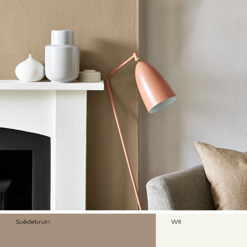 Gezellige hoek met beige muur, witte schouw en roze vloerlamp